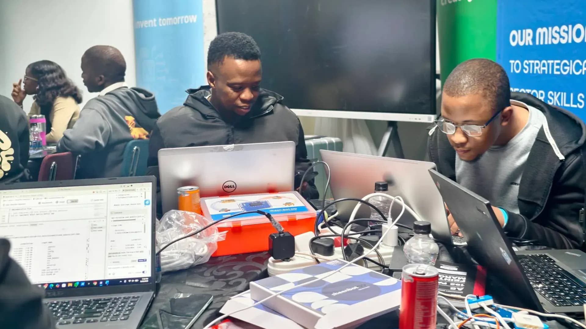 Students at the CPUT hackathon working on laptops around a sheenbot kit and sensor modules